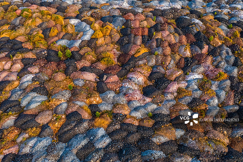 露天铁矿采石场矿石堆场的鸟瞰图。五颜六色的矿石堆图片素材