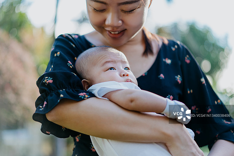 亚洲母亲在后院抱着她的男婴图片素材