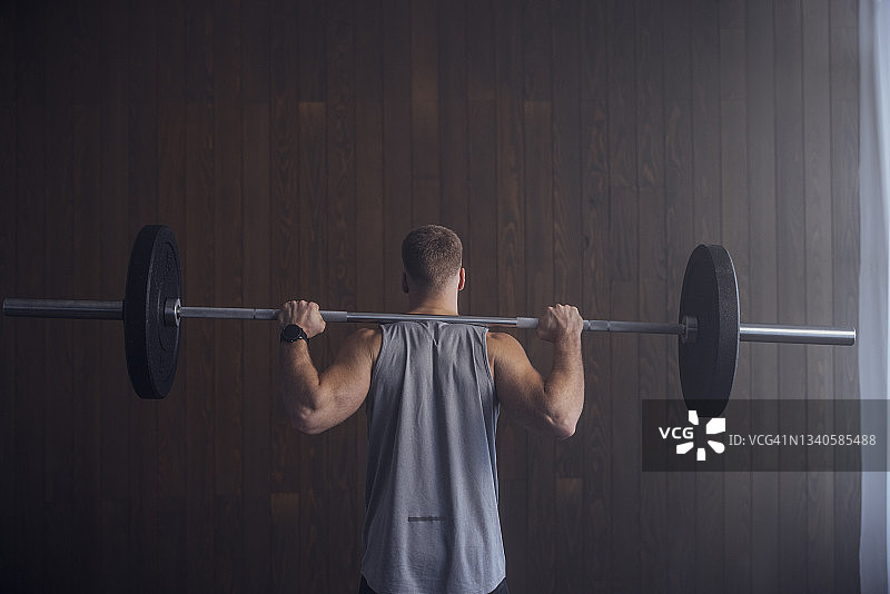 综合健身:一个男人用杠铃锻炼图片素材