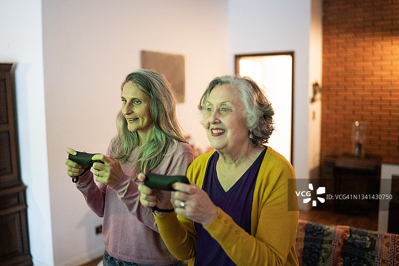 女儿和妈妈在家里玩电子游戏图片素材