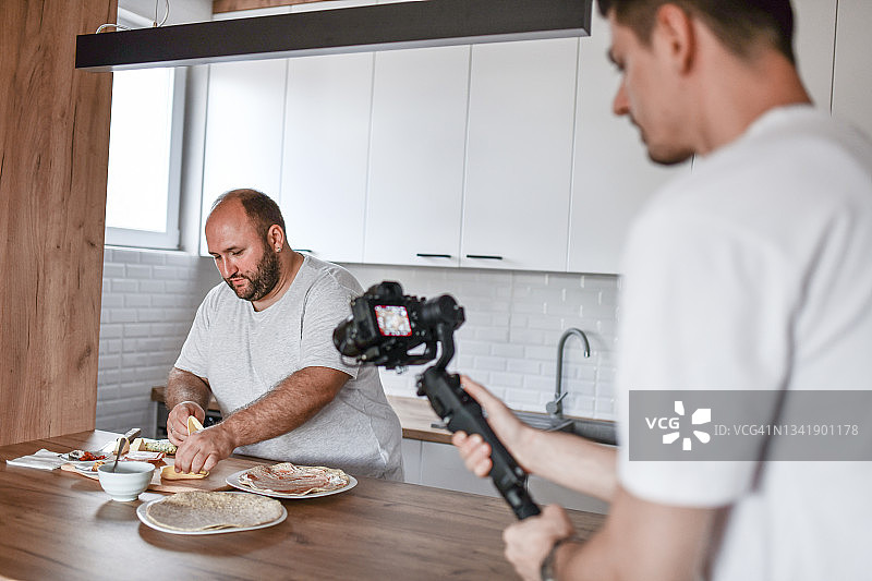 男性录制关于在家做玉米卷的视频博客图片素材