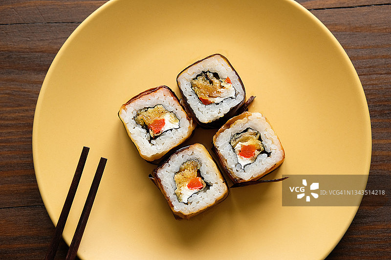 寿司被端上或放在陶瓷盘子上，放在厨房或餐桌上。在家做饭。素食者和纯素食品和饮食。图片素材