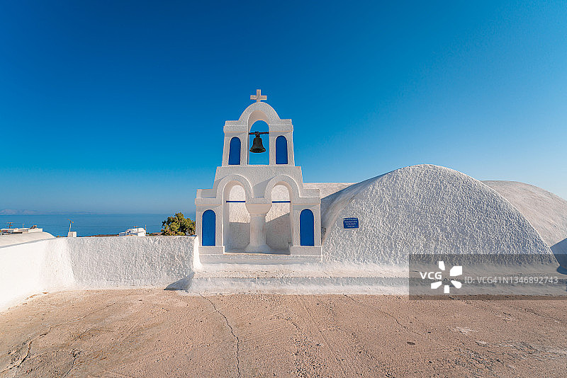希腊圣托里尼岛伊亚村的蓝色圆顶和白色教堂钟塔图片素材