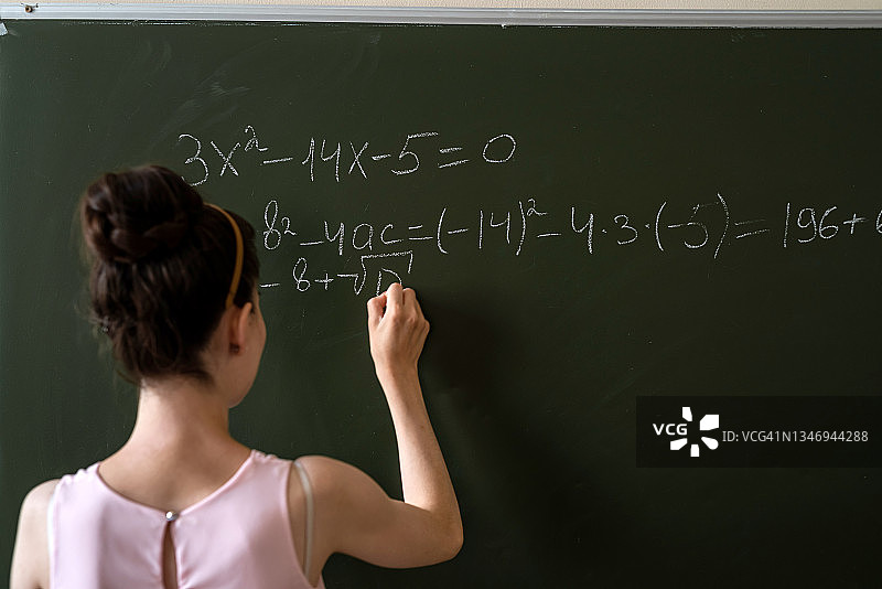 女大学生在黑板上写数学方程图片素材