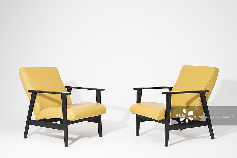 两个现代的黄色扶手椅在白色的背景上图片素材