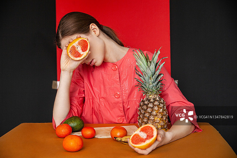 画室里的女人在餐桌上吃着热带水果图片素材
