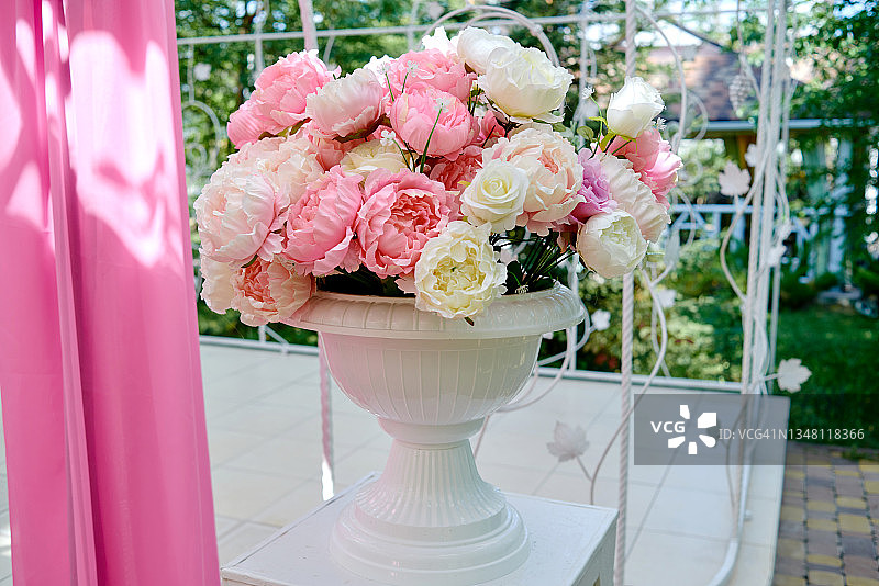 白色和粉红色的花束在古董花瓶在户外的桌子上，自由的空间。婚礼花卉装饰。为婚礼准备的漂亮衣服图片素材