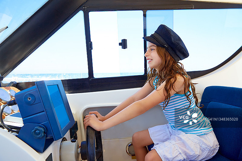 小女孩在船上装成船长，戴着水手帽图片素材