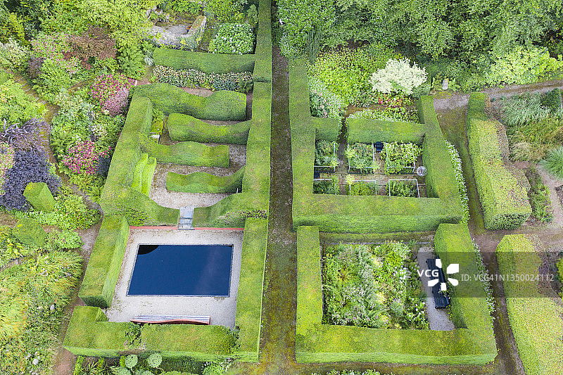俯瞰花园的一部分，有紫杉的正规树篱，包含有花坛、边界和水池的矩形花园;英国威尔士，蒙茅斯郡，Veddw House Garden。9月。夏天。无人机拍摄的图像。图片素材