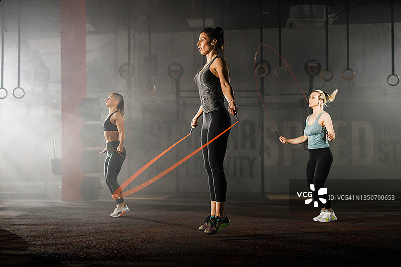 女运动员在体育馆里用跳绳运动。图片素材