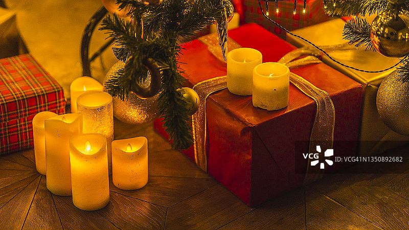 圣诞节和新年室内装饰。绿树上装饰着玩具、礼物、礼品盒、蜡烛。圣诞树。舒适的圣诞气氛图片素材