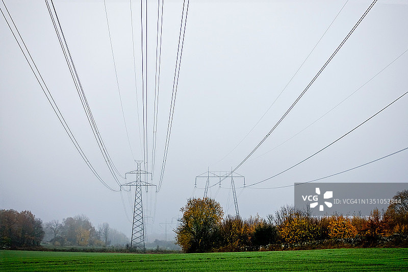 在秋天，电线穿过农业景观图片素材