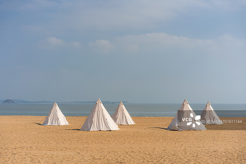 在阳光明媚的日子里在海滩上搭帐篷图片素材