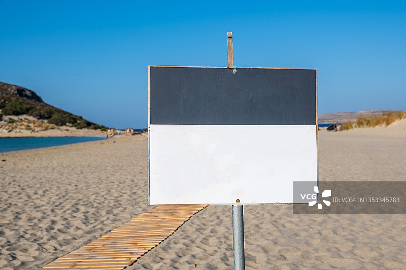 标志白色白板上的后模糊的沙滩背景。广告模板、复制空间。图片素材