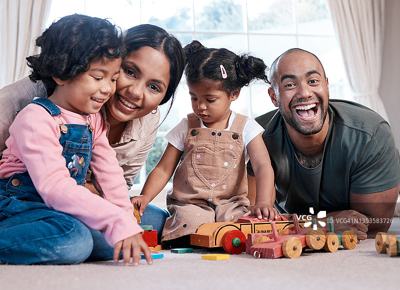 一个幸福的家庭在家里一起玩木制玩具的肖像图片素材