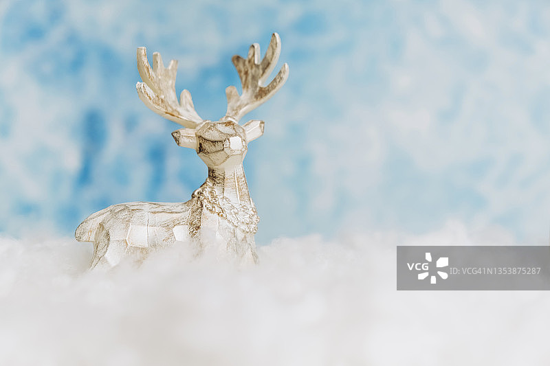 玩具圣诞鹿在天空的雪背景上图片素材
