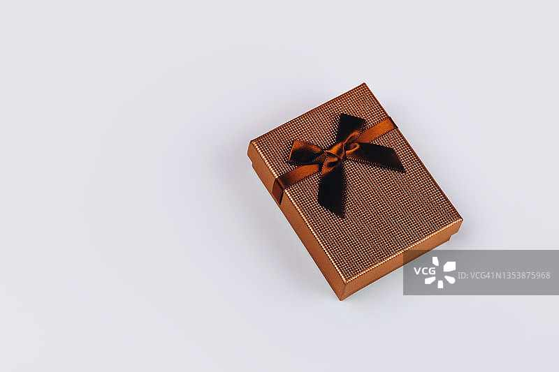 棕色的礼品盒与丝带和大蝴蝶结在白色的背景。图片素材