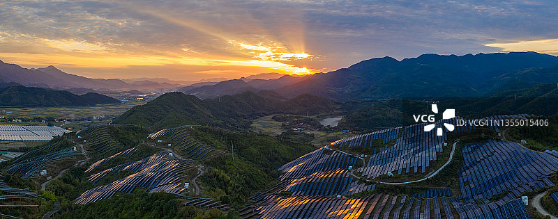 黄昏时山顶上的太阳能光伏电站的航拍图片素材