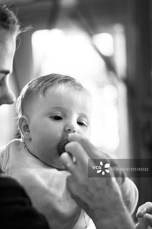 婴儿在母亲的帮助下尝试食物图片素材