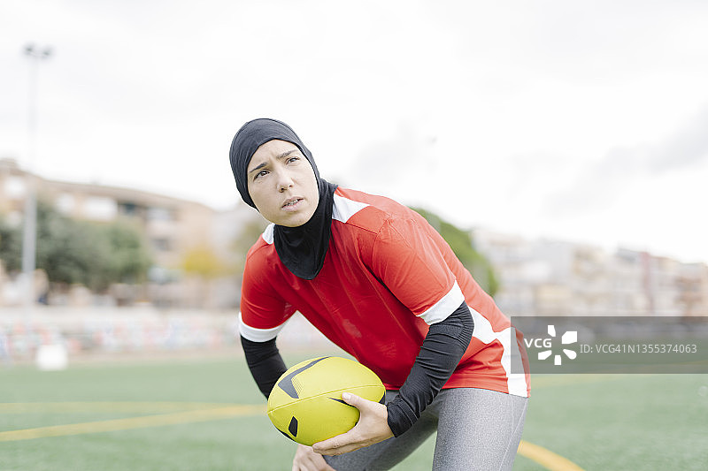 运动的阿拉伯妇女在运动场上打橄榄球。图片素材