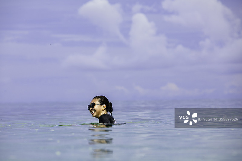 在海滩上游泳的亚洲年轻女子图片素材