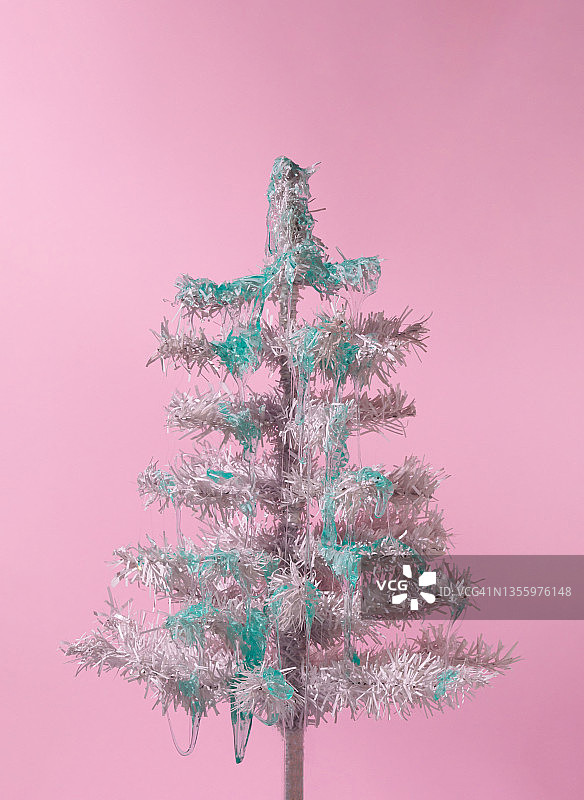 最小的构图背景白色圣诞树与蓝色黏液在柔和的粉红色。新年的概念。图片素材