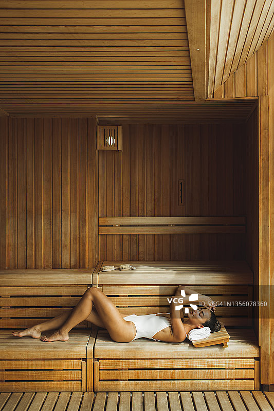 年轻美丽苗条的女人放松在温泉。图片素材