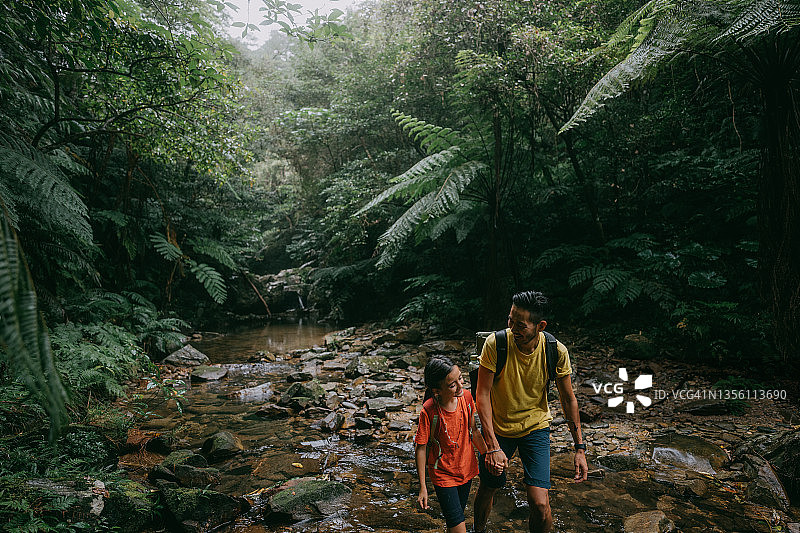父亲和女儿在日本冲绳丛林中徒步旅行图片素材