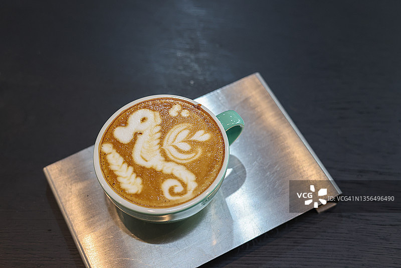 拿铁或卡布奇诺与泡沫，咖啡杯顶部视图在咖啡馆的桌子上。图片素材