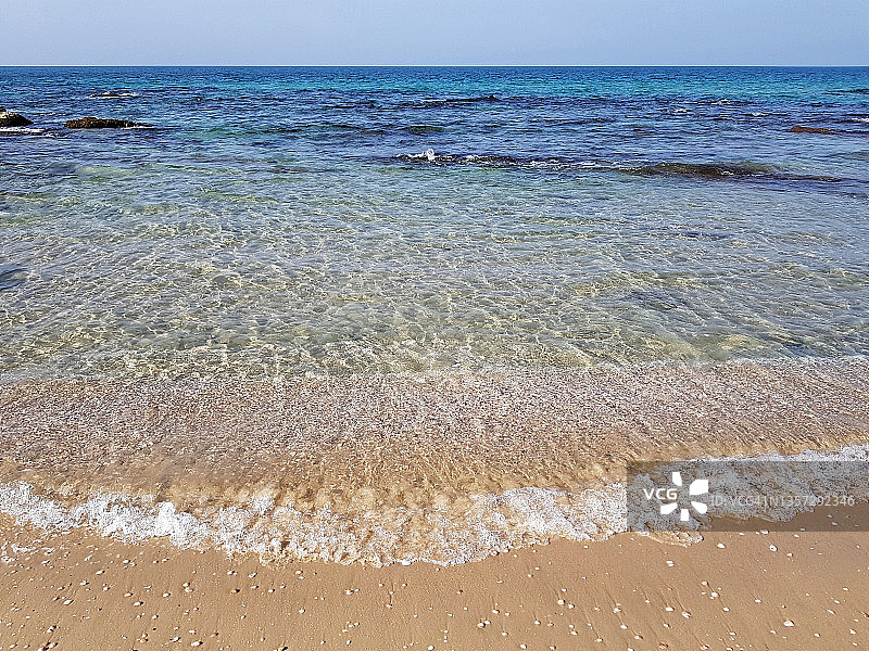 阳光明媚的海景，海浪涌上岸，地中海东部的水边图片素材