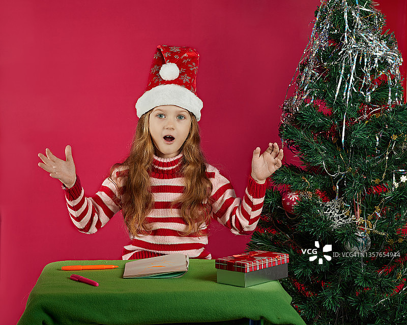 圣诞节，假日和童年概念-微笑的女孩制作愿望清单或写信给圣诞老人在家图片素材