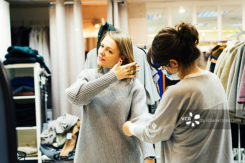 两个中年妇女在一家时装店挑选衣服图片素材