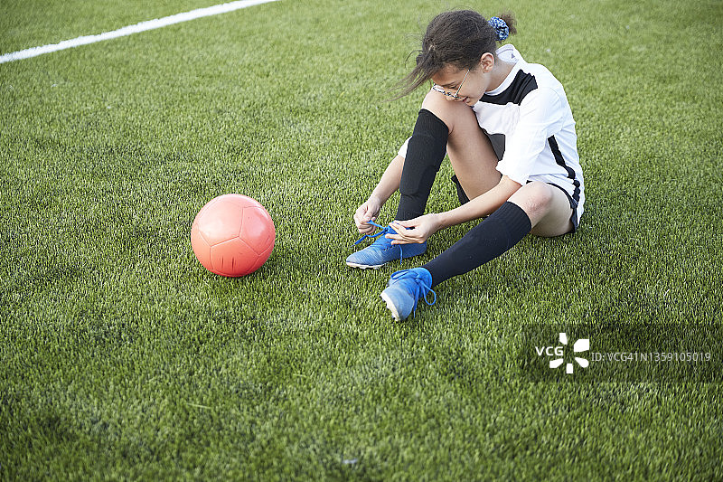 英国，女足球运动员在球场上系鞋图片素材