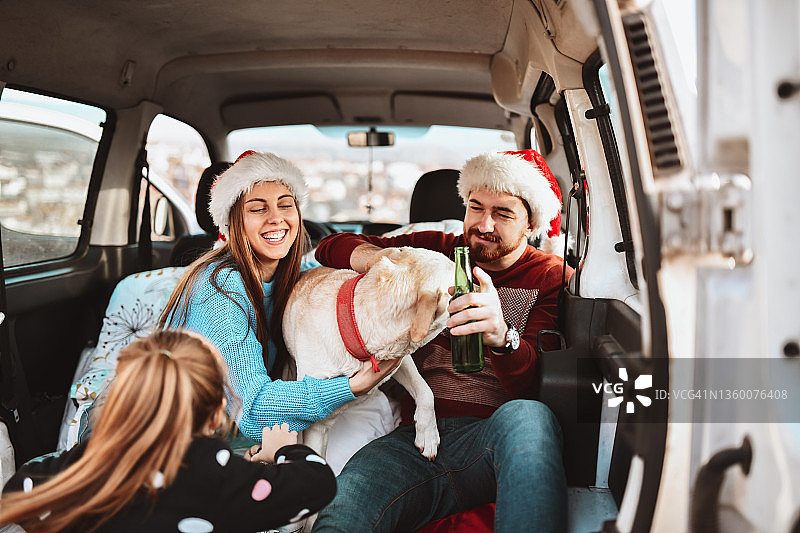 一家人带着圣诞帽在小货车里玩狗图片素材