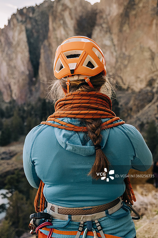 在俄勒冈州中部，一名女性攀岩者在身上绑上一根登山绳，可以看到山景图片素材