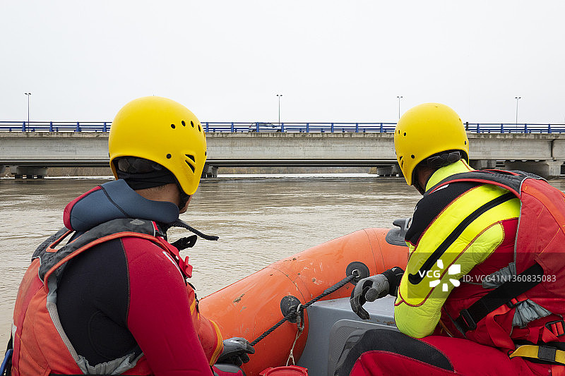 两名救援人员从船上观察河水图片素材