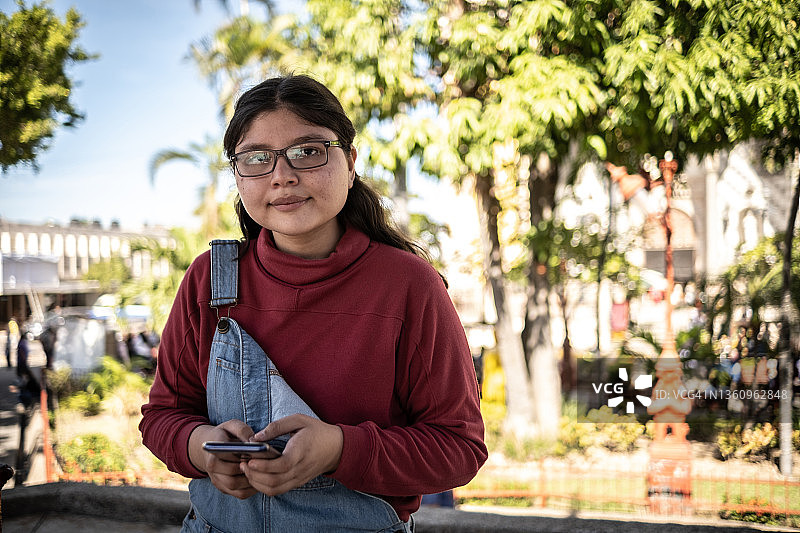 一名年轻女子在户外使用智能手机的肖像图片素材