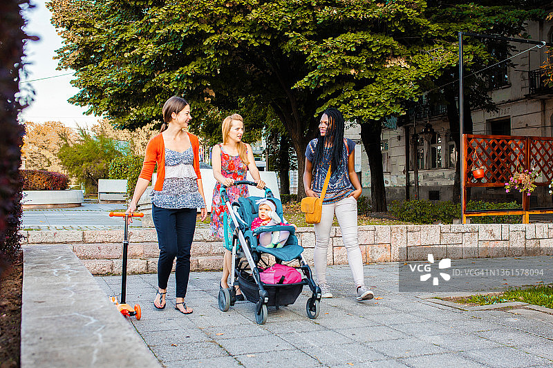 三个女性朋友在城市公园散步图片素材