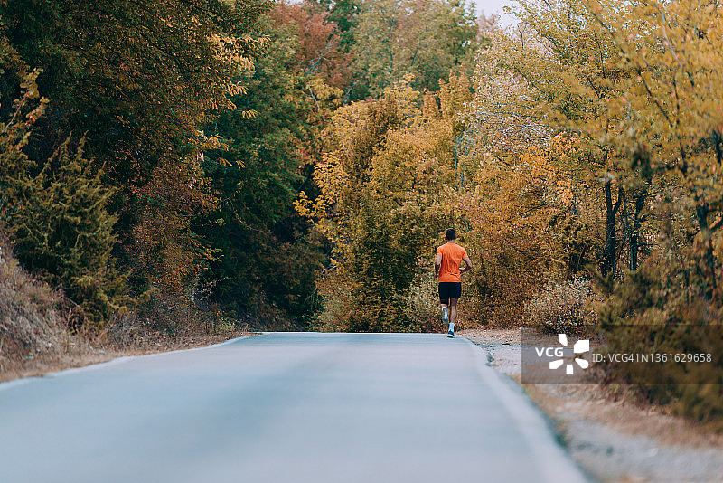 跑步运动员在森林小道上跑步。男士健身慢跑健身养生理念图片素材