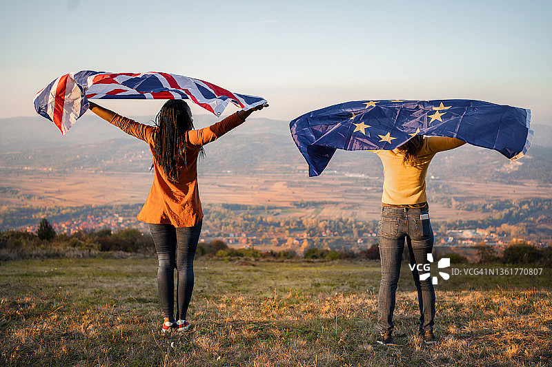 两名妇女站在山上，举着欧盟和英国的国旗图片素材
