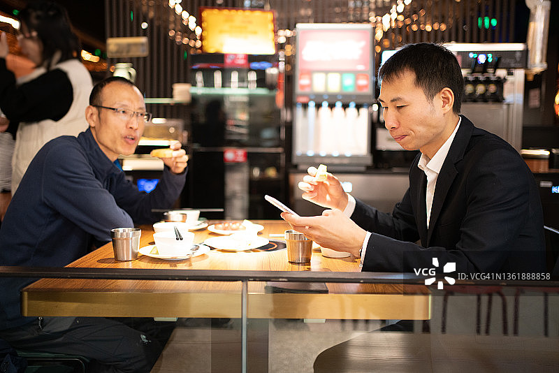 两个亚洲人正在吃饭聊天图片素材