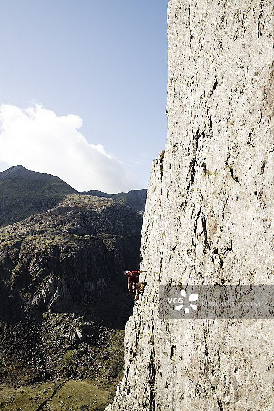 男性攀岩者攀登大岩壁图片素材