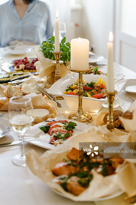 餐桌上摆满了食物、美酒和蜡烛。图片素材