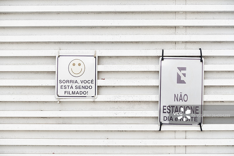 巴西一栋建筑外挂着禁止停车和“对着镜头微笑”的标牌图片素材