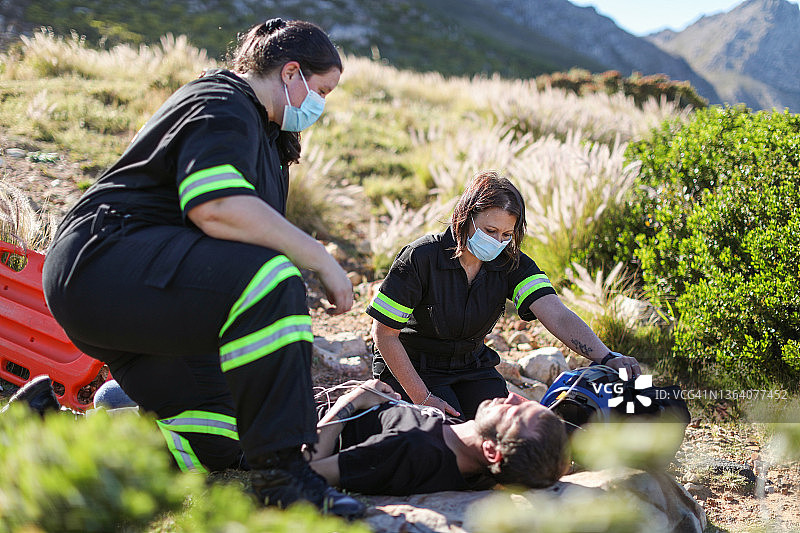 两名女护理人员正在协助一名伤者。图片素材