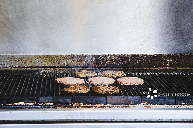 汉堡肉饼在不锈钢烧烤架上烘烤图片素材