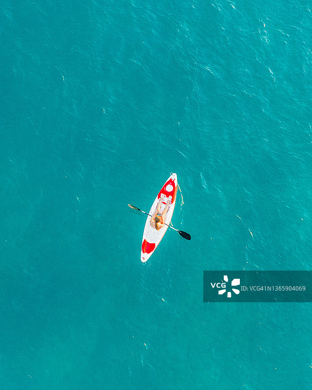 鸟瞰图，阿尔巴尼亚女子在碧绿的大海上划皮艇图片素材