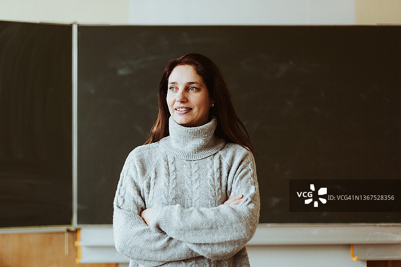 微笑的女老师站在黑板前图片素材