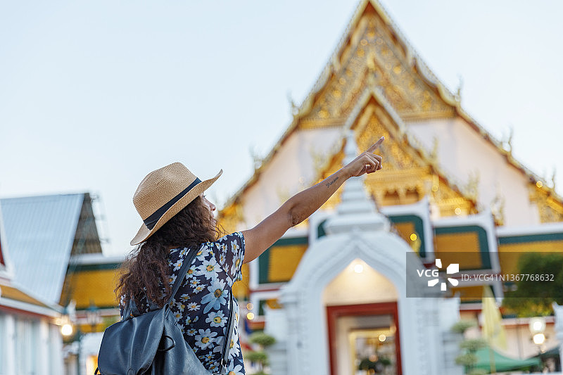 在泰国曼谷美丽的寺庙里，年轻的拉丁女性游客微笑着，快乐地度假。图片素材