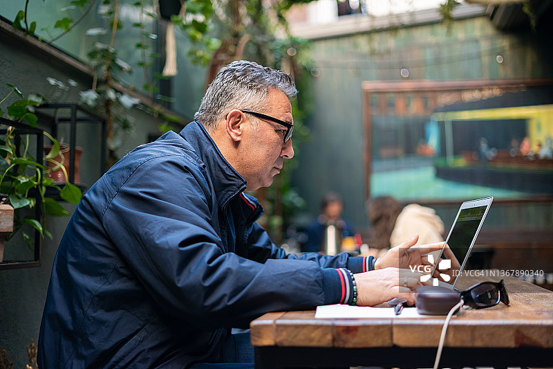 一个成年人在咖啡馆用笔记本电脑工作图片素材